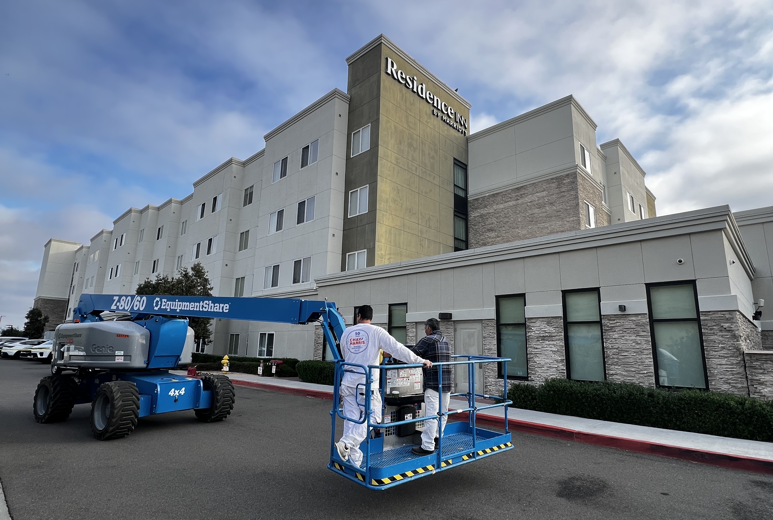 Commercial building exterior painting — professional crew on scaffolding