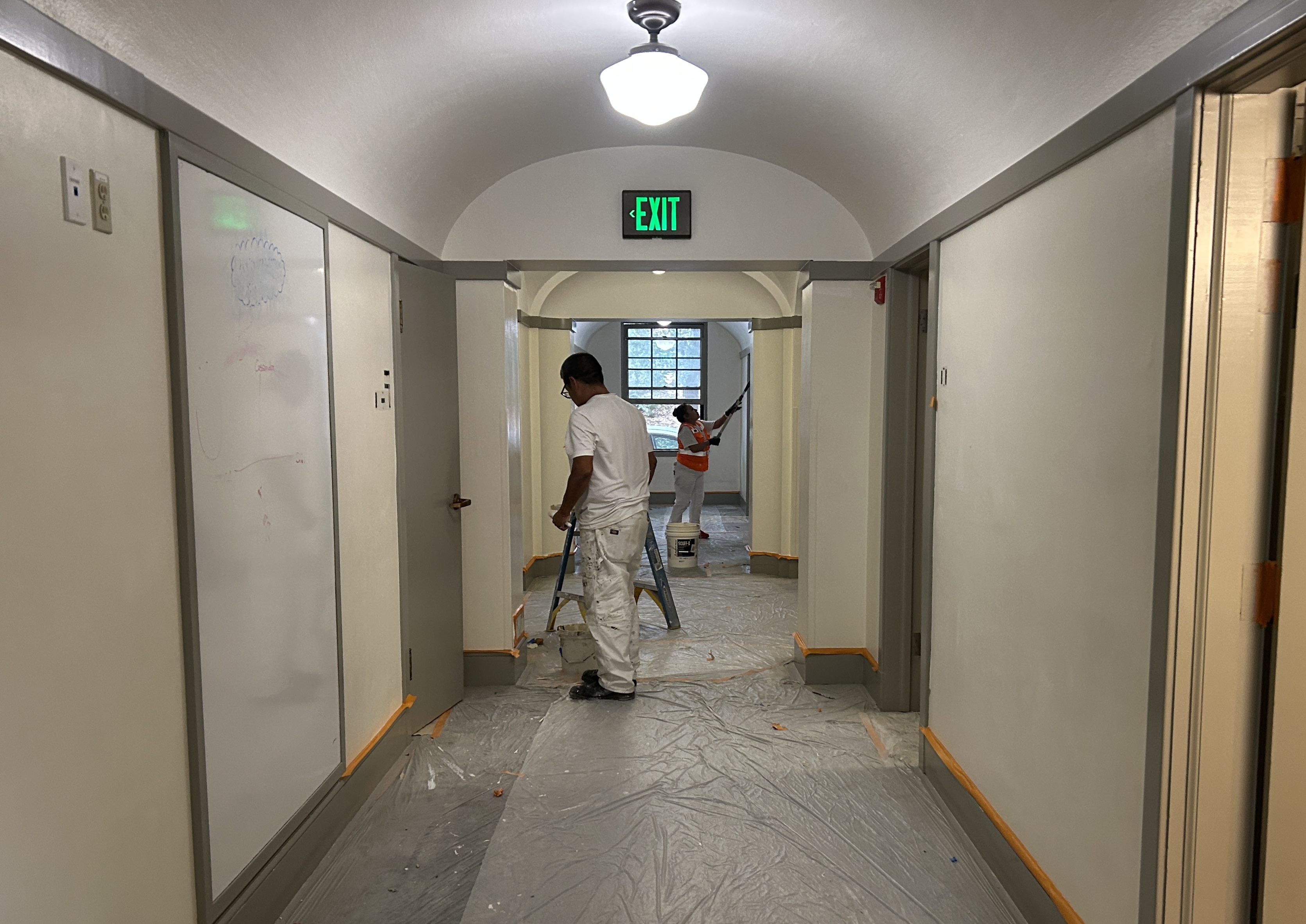 Professional painter rolling commercial interior ceiling
